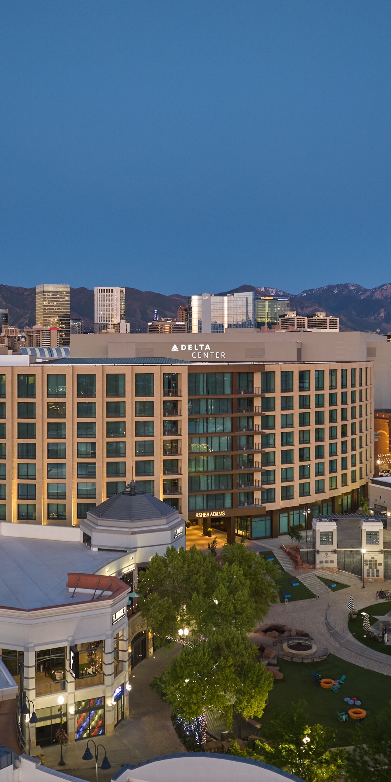 Hotel exterior at dusk with city skyline