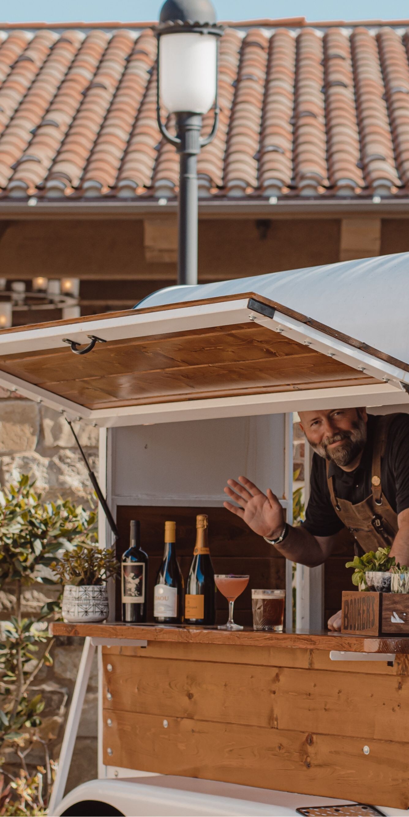 Bartender inside a small outdoor trailer bar
