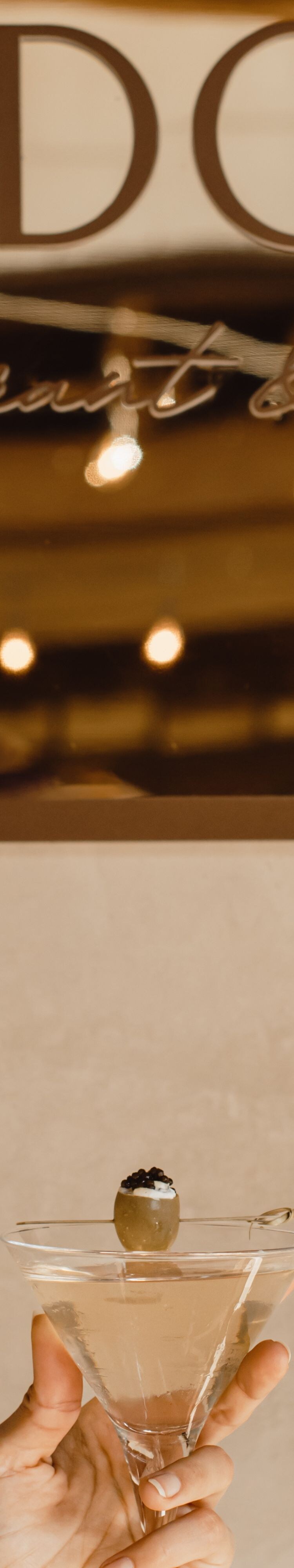 Martini held up in front of Ysidora Restaurant sig