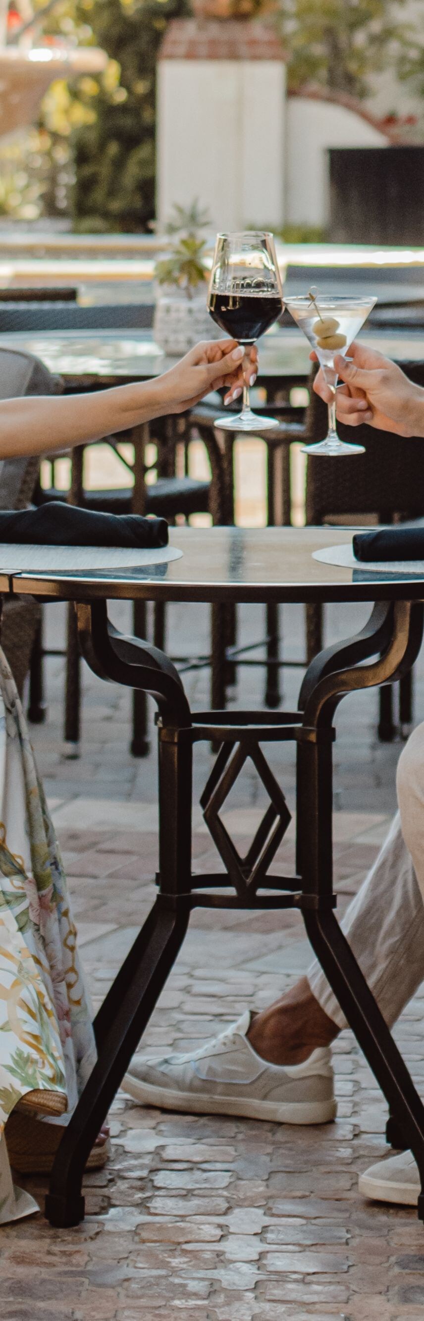 Guests toasting drinks at outdoor poolside table
