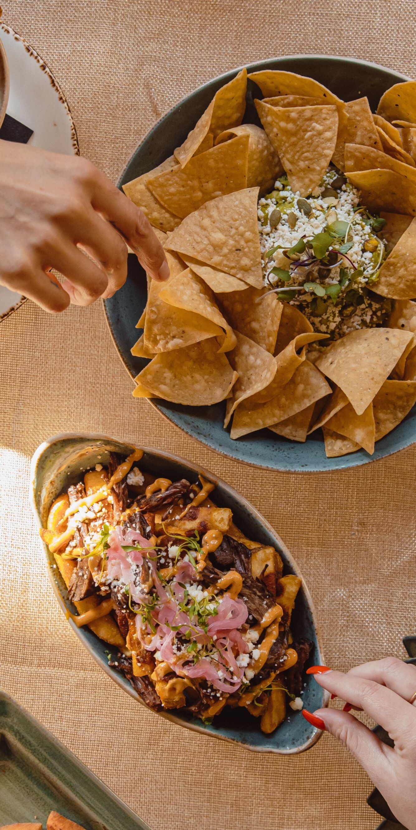 Overhead view of tortilla chips, loaded fries, coc