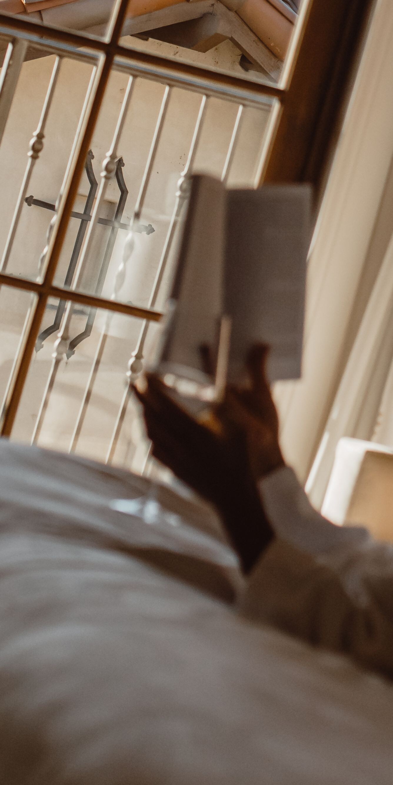Guest in a robe relaxing on a bed reading near