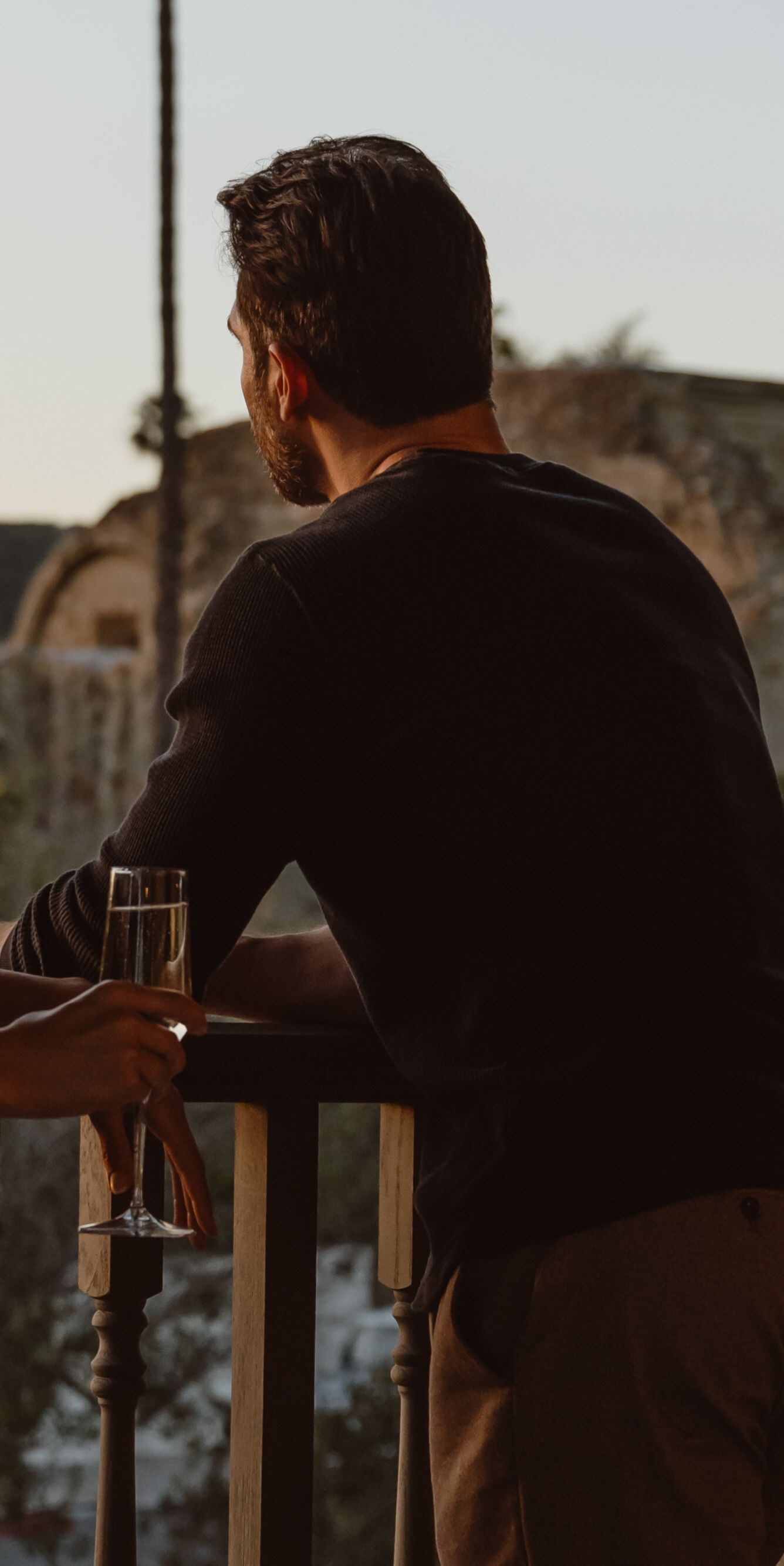 Couple holding champagne on a balcony overlooking 