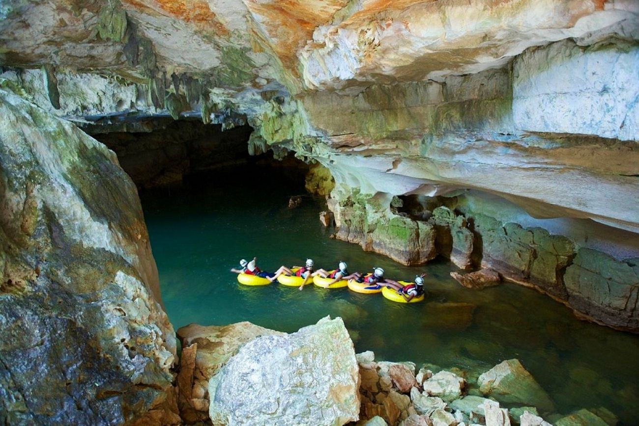 Five people in inner tubes exploring a cave.