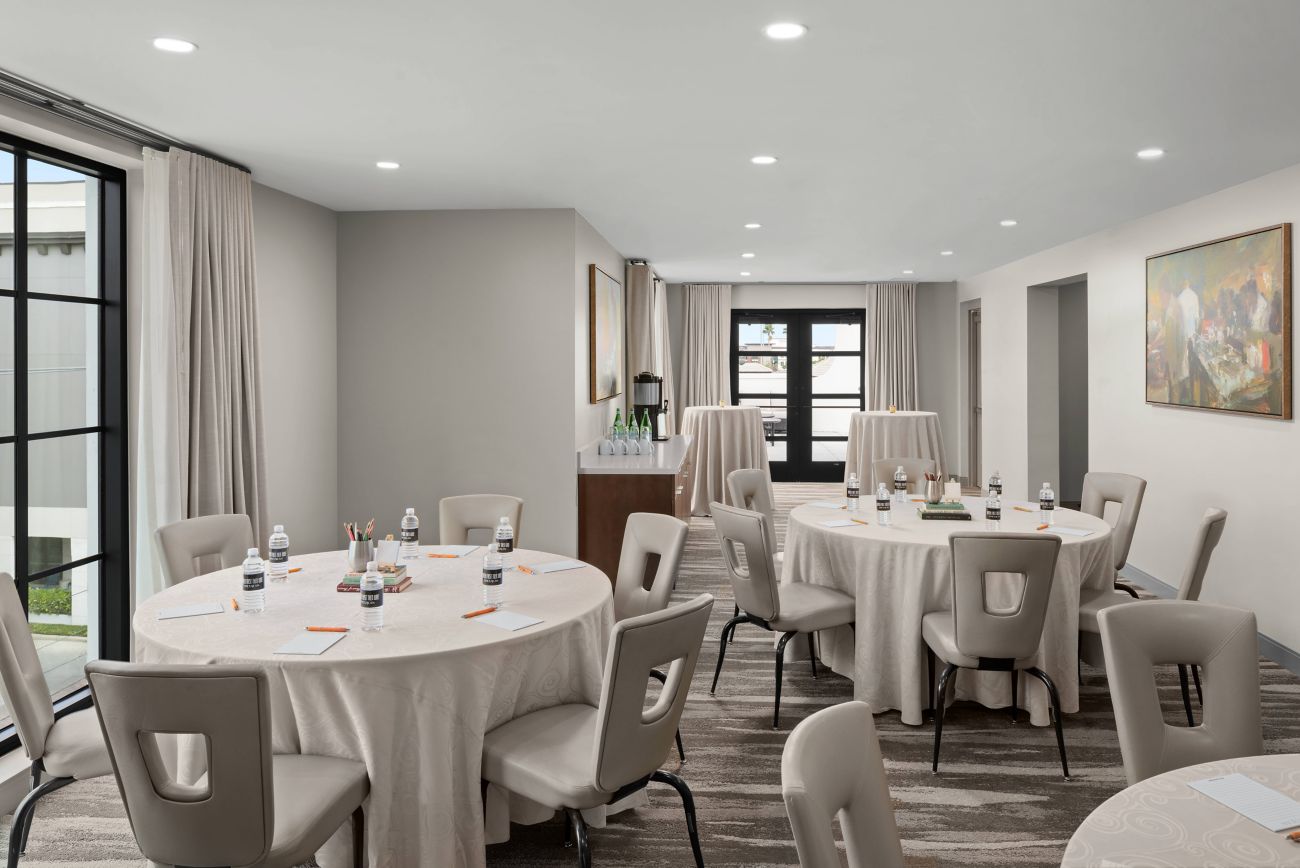A room with tables and chairs by Epicurean Hotel