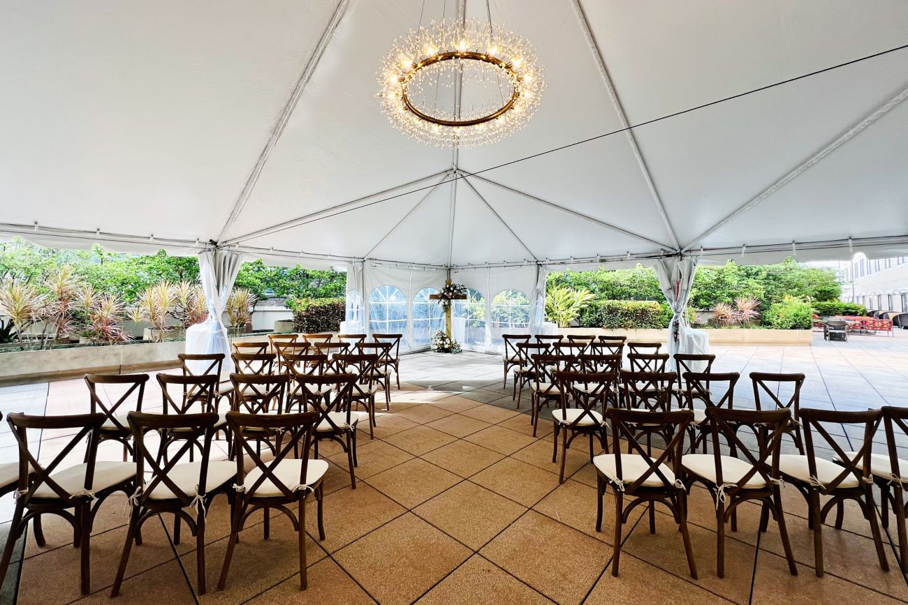 A white tent with chairs and chandelier
