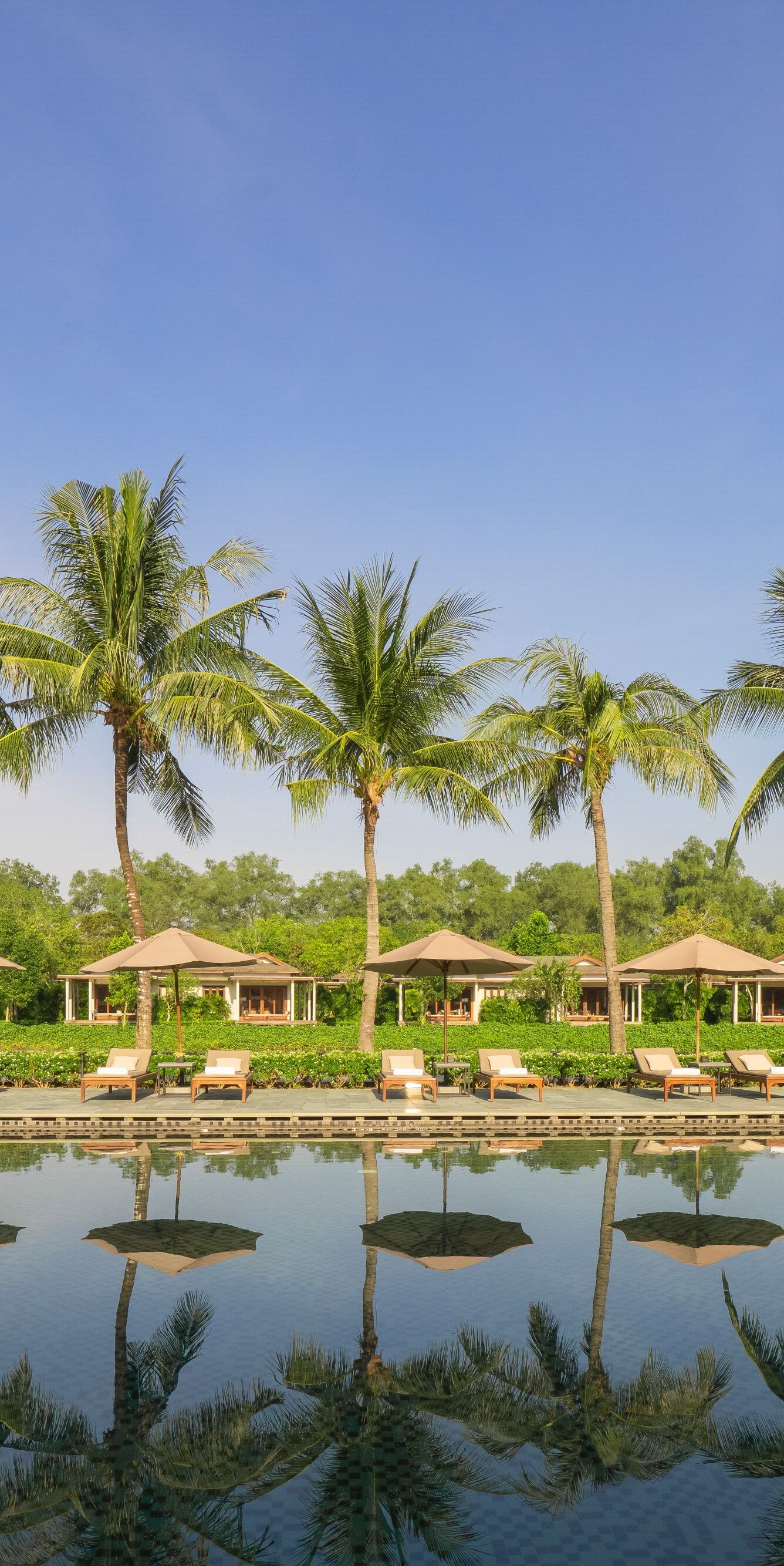 Tropical cabanas by a tranquil pool.