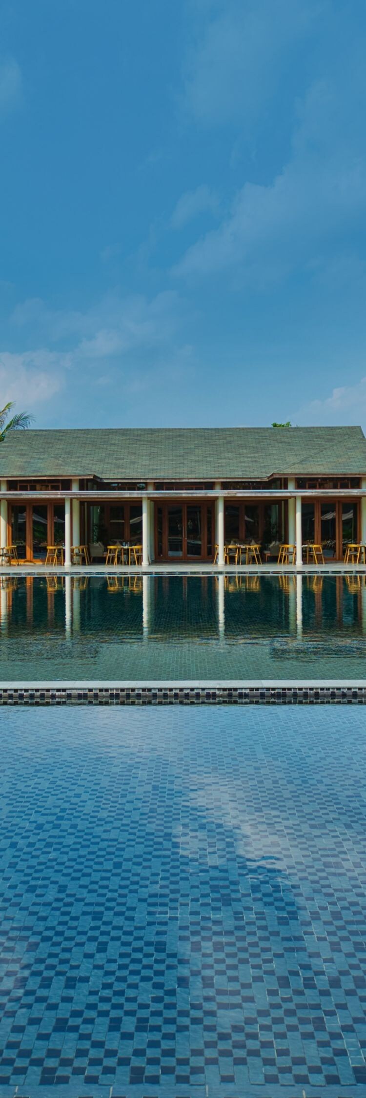 Swimming pool with sun loungers in daylight.