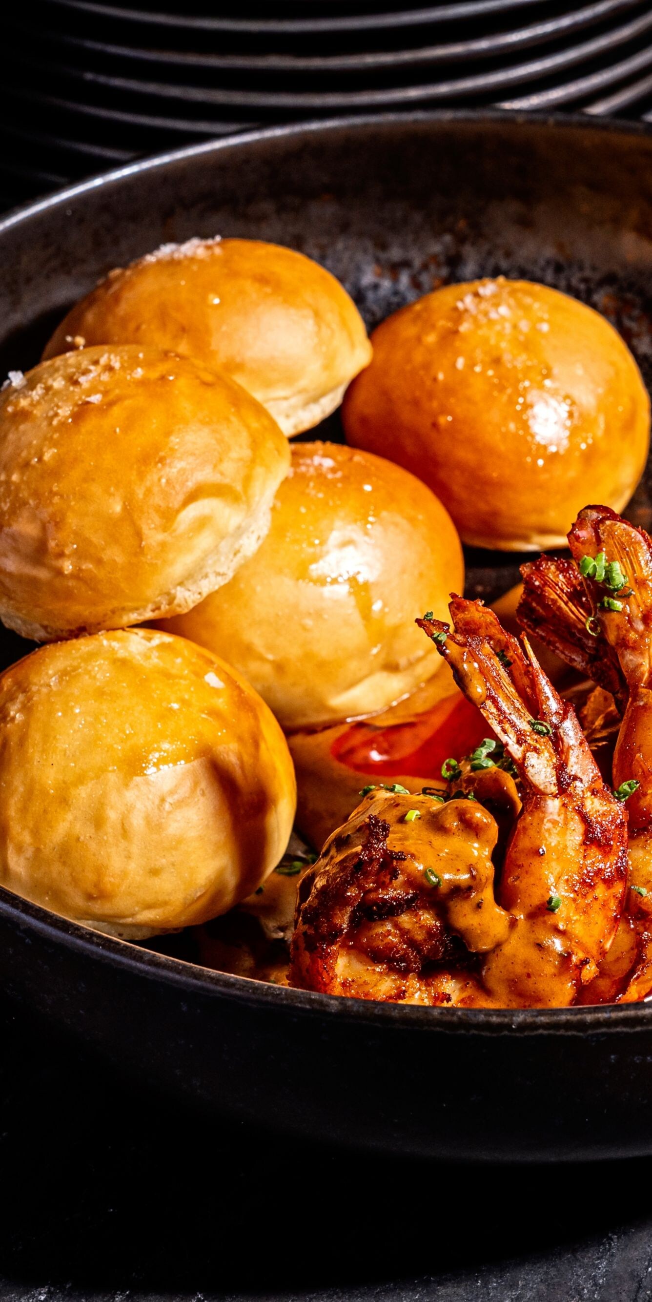 Shrimp with rolls in a black bowl