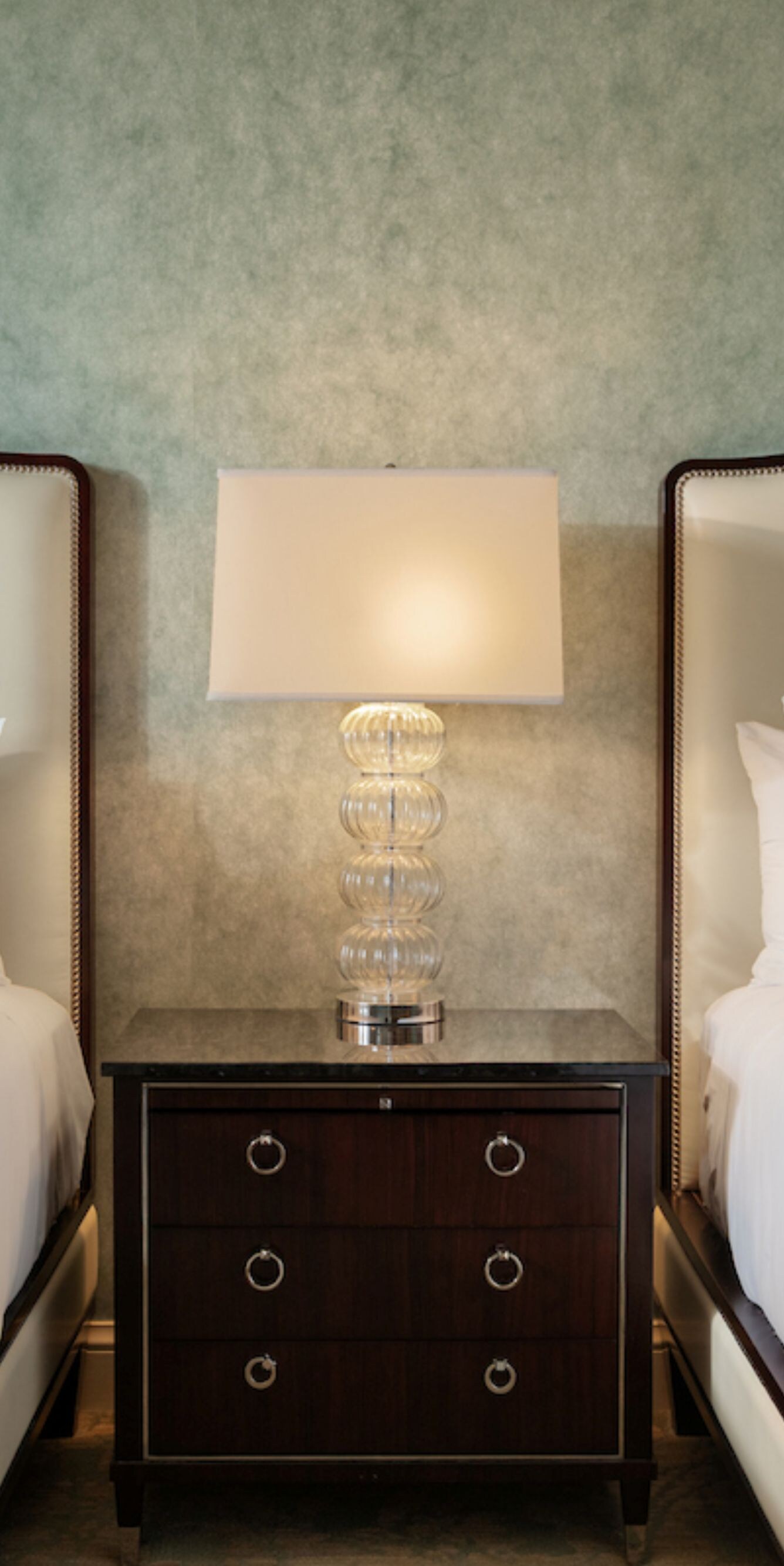 Guest room with two queen beds and bedside table