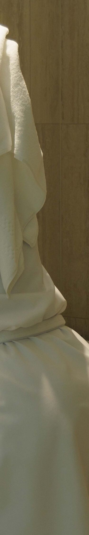 Client en peignoir se lavant le visage dans une salle de bain moderne