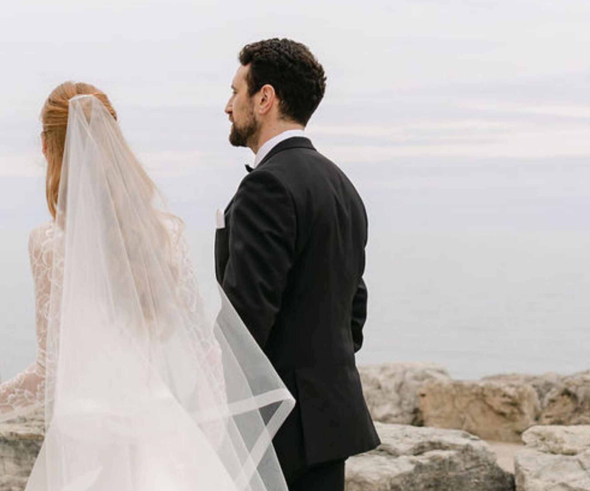 Bride and groom with bouquet by waterfront