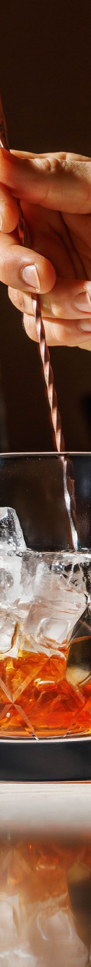 Barman remuant un cocktail classique derrière 