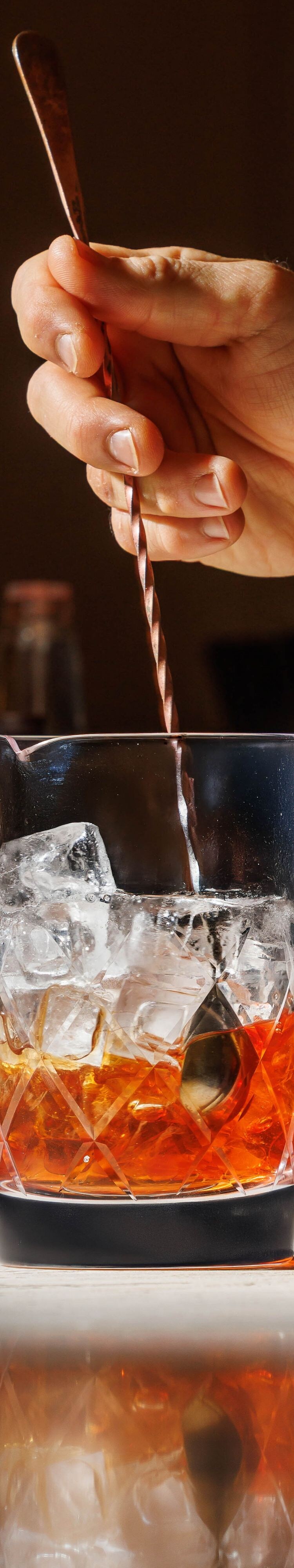 Barman remuant un cocktail classique derrière 