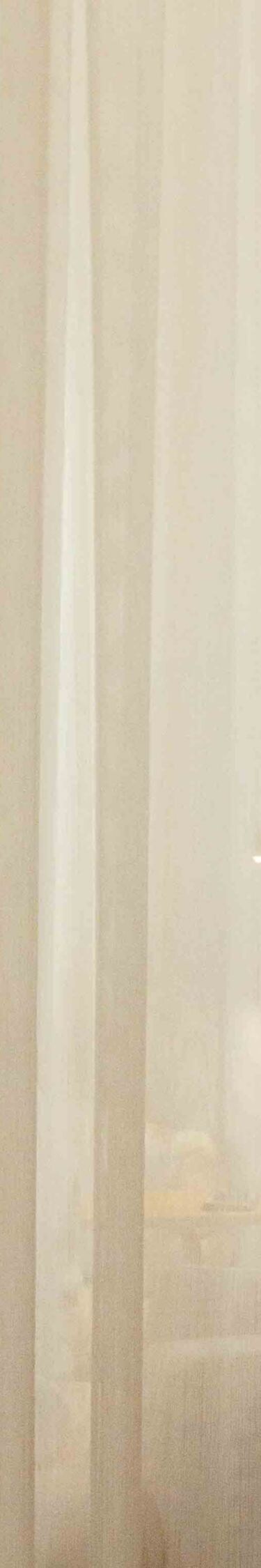 Des rideaux transparents filtrent la lumière du jour dans un hôtel.