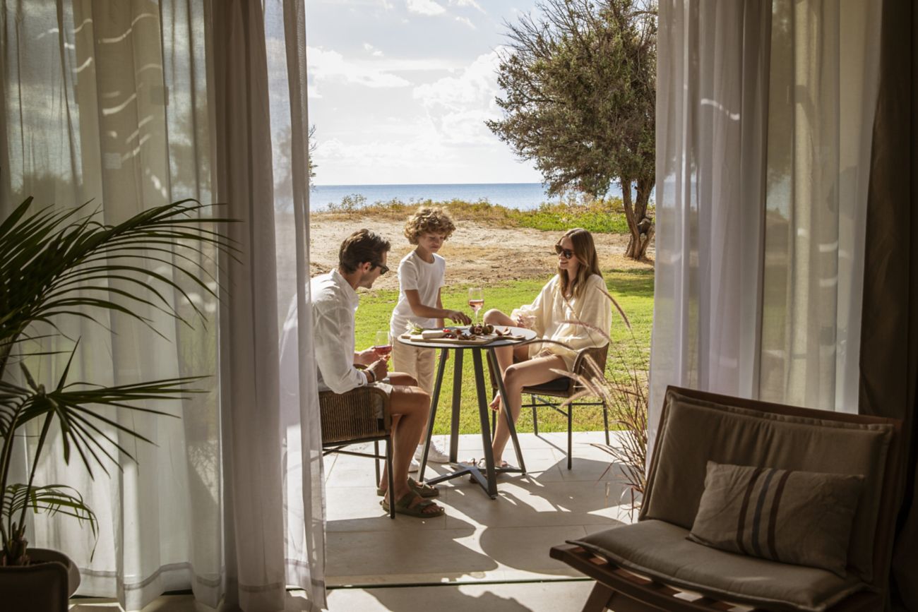 A family enjoying the suite patio with sea view  