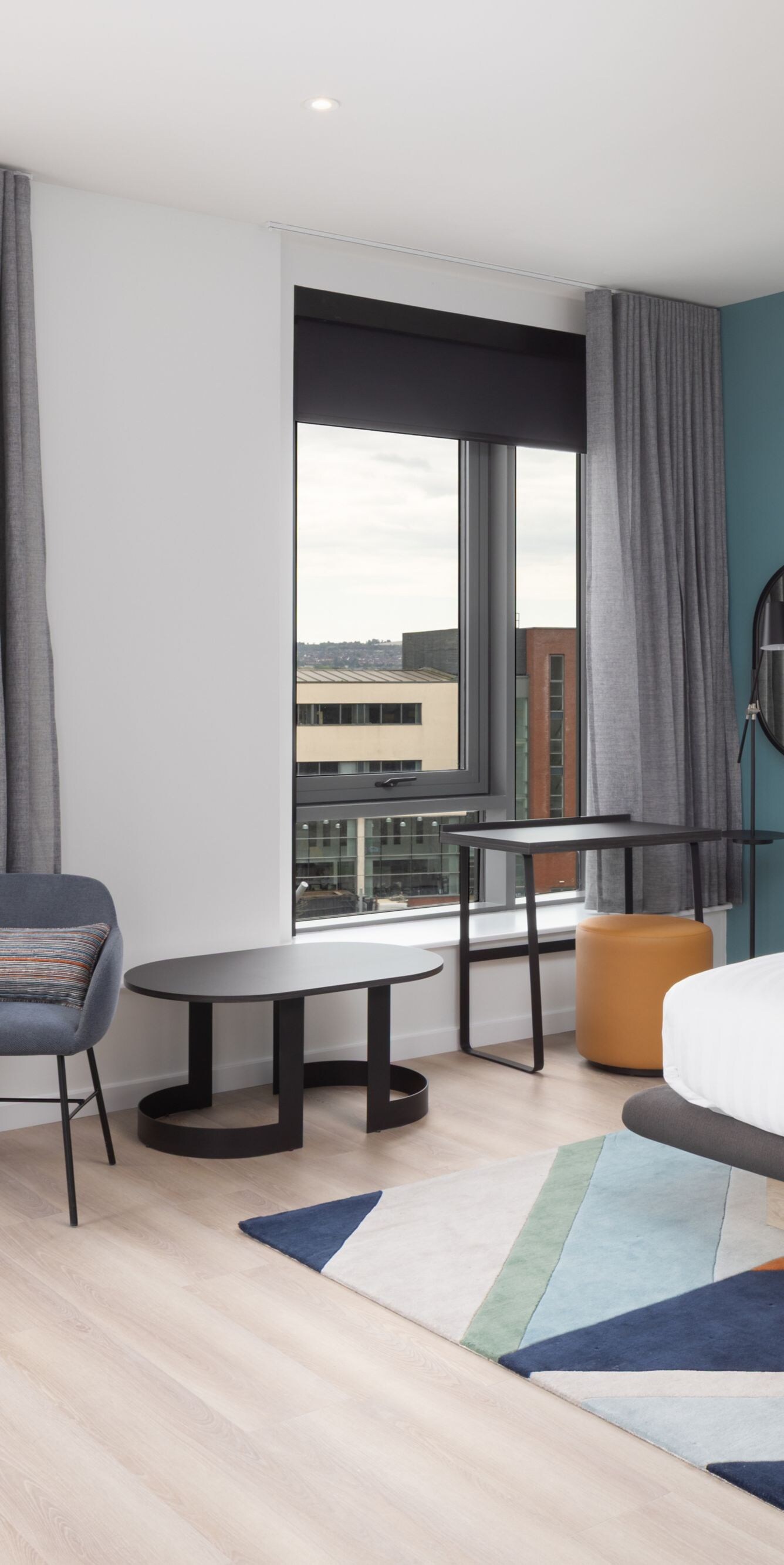 Modern hotel room with bed, chairs and windows