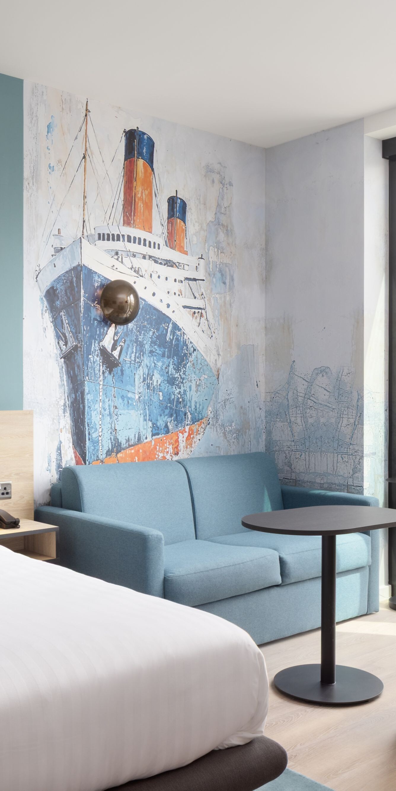 King room with sofa bed and ship artwork on walls