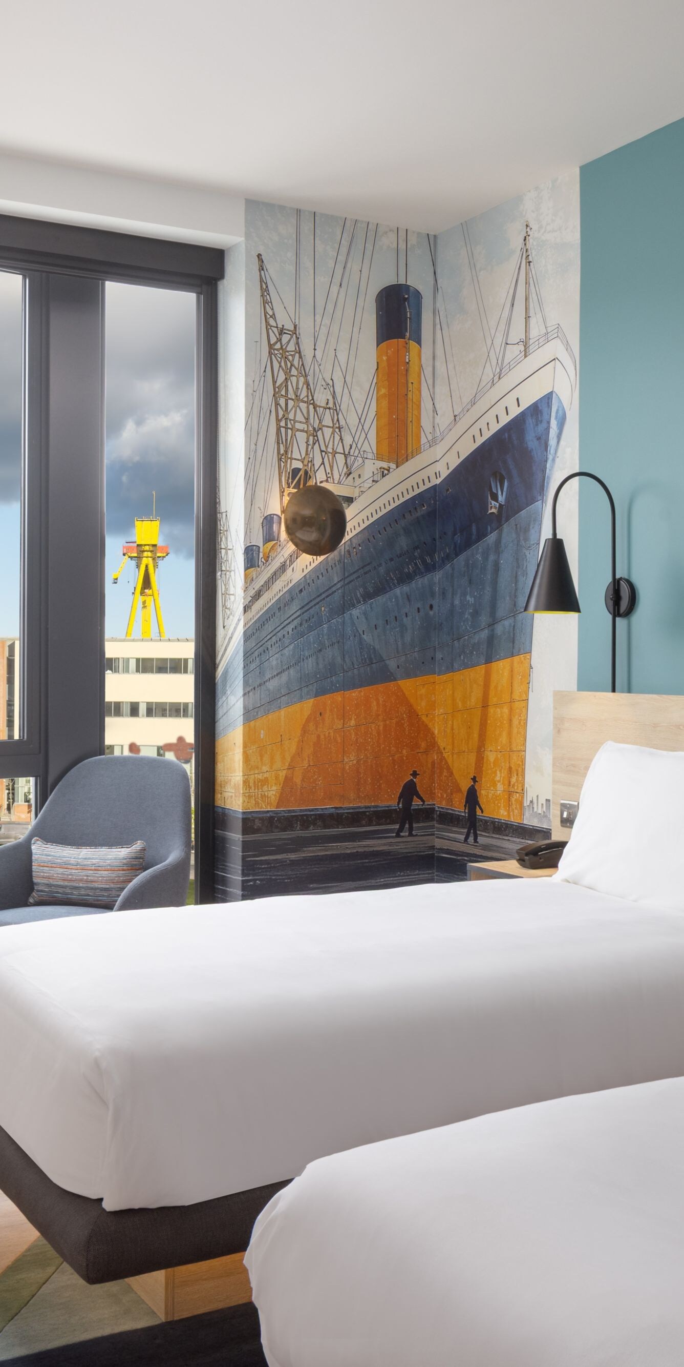 Hotel room with two beds ship mural and window