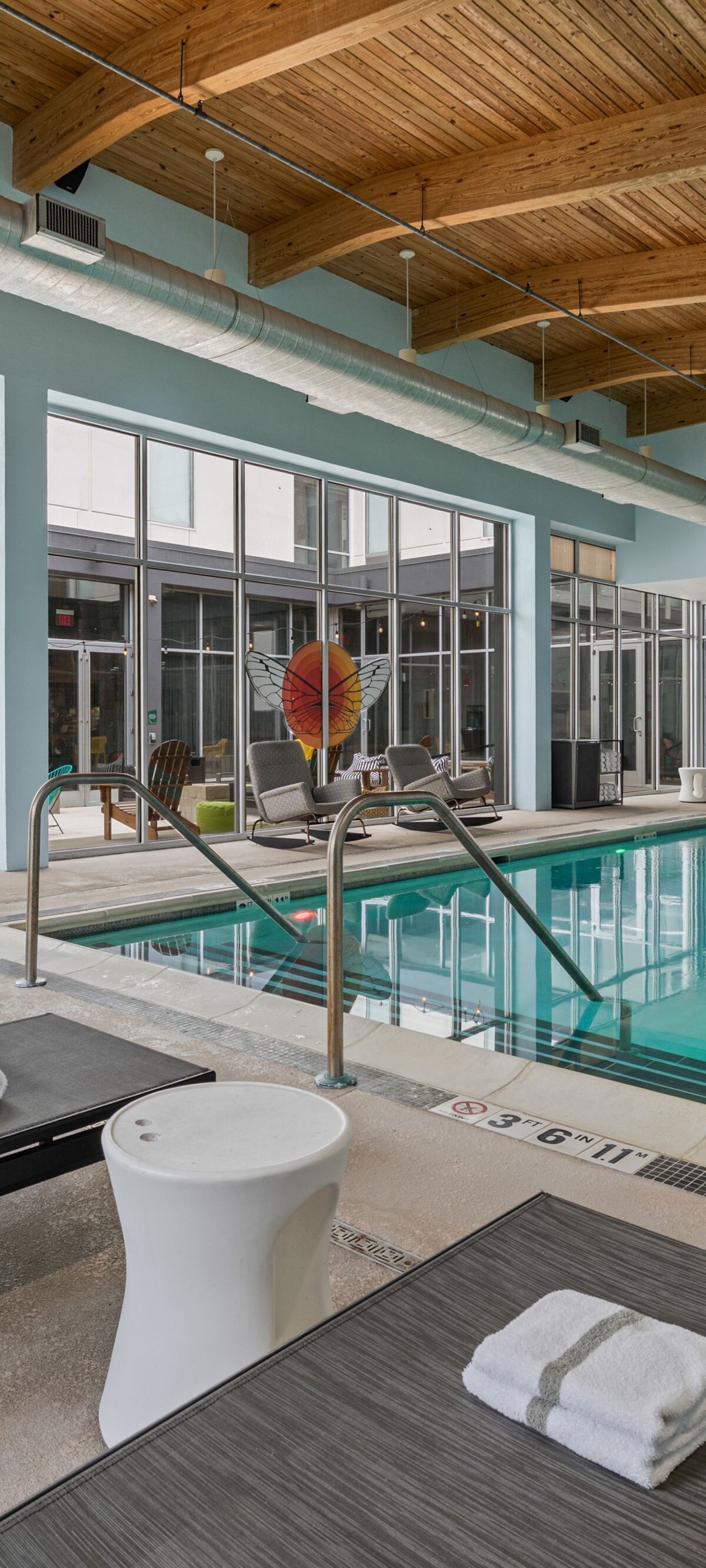 Indoor pool with surrounding lounge seating