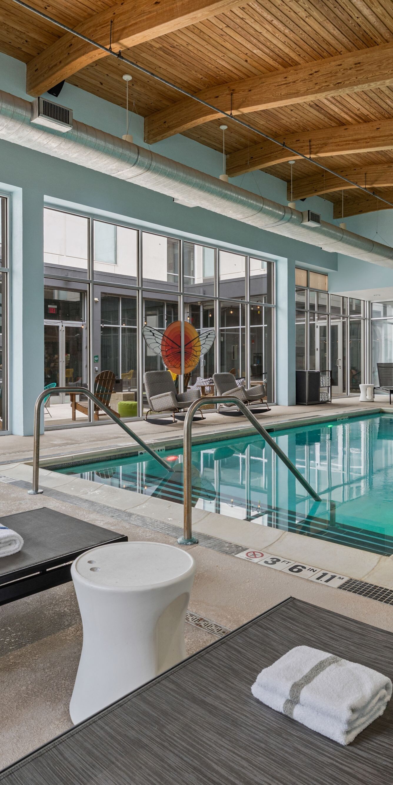 Indoor pool with surrounding lounge seating