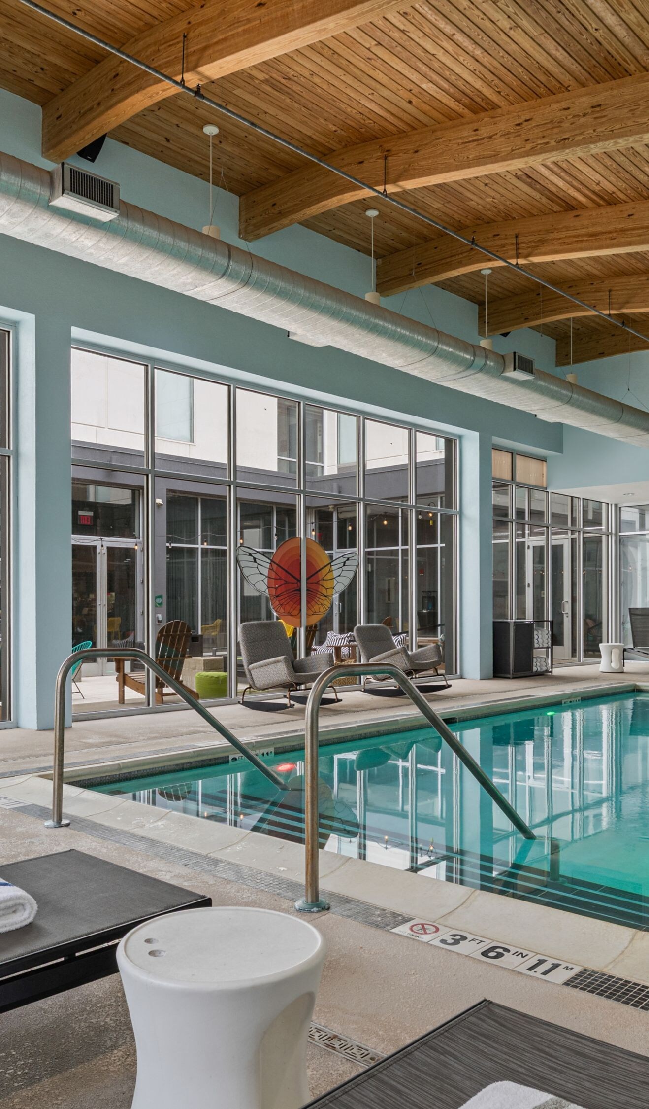 Indoor pool with surrounding lounge seating