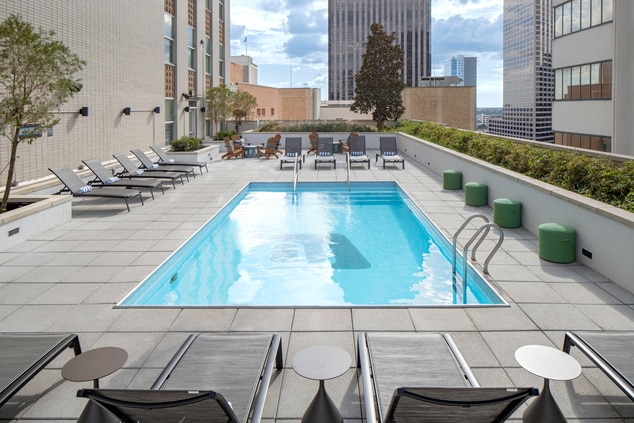 Pool with seating in city on rooftop during the da