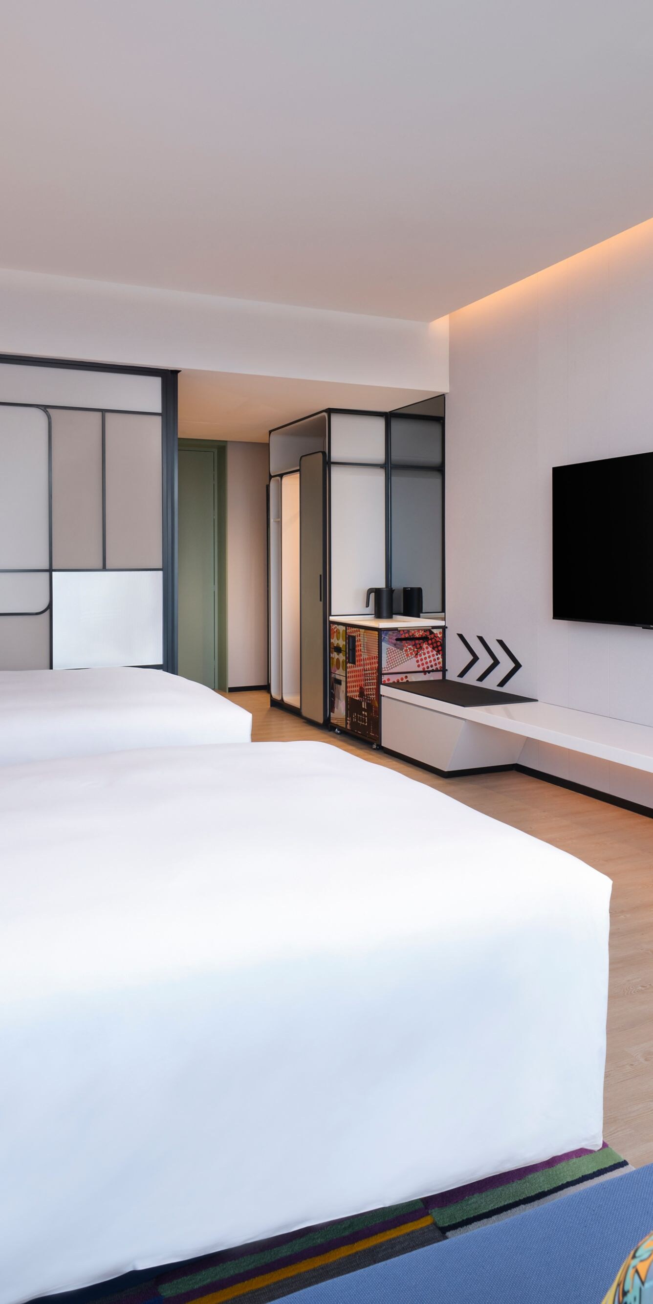 Guest room bed with chair, table, TV