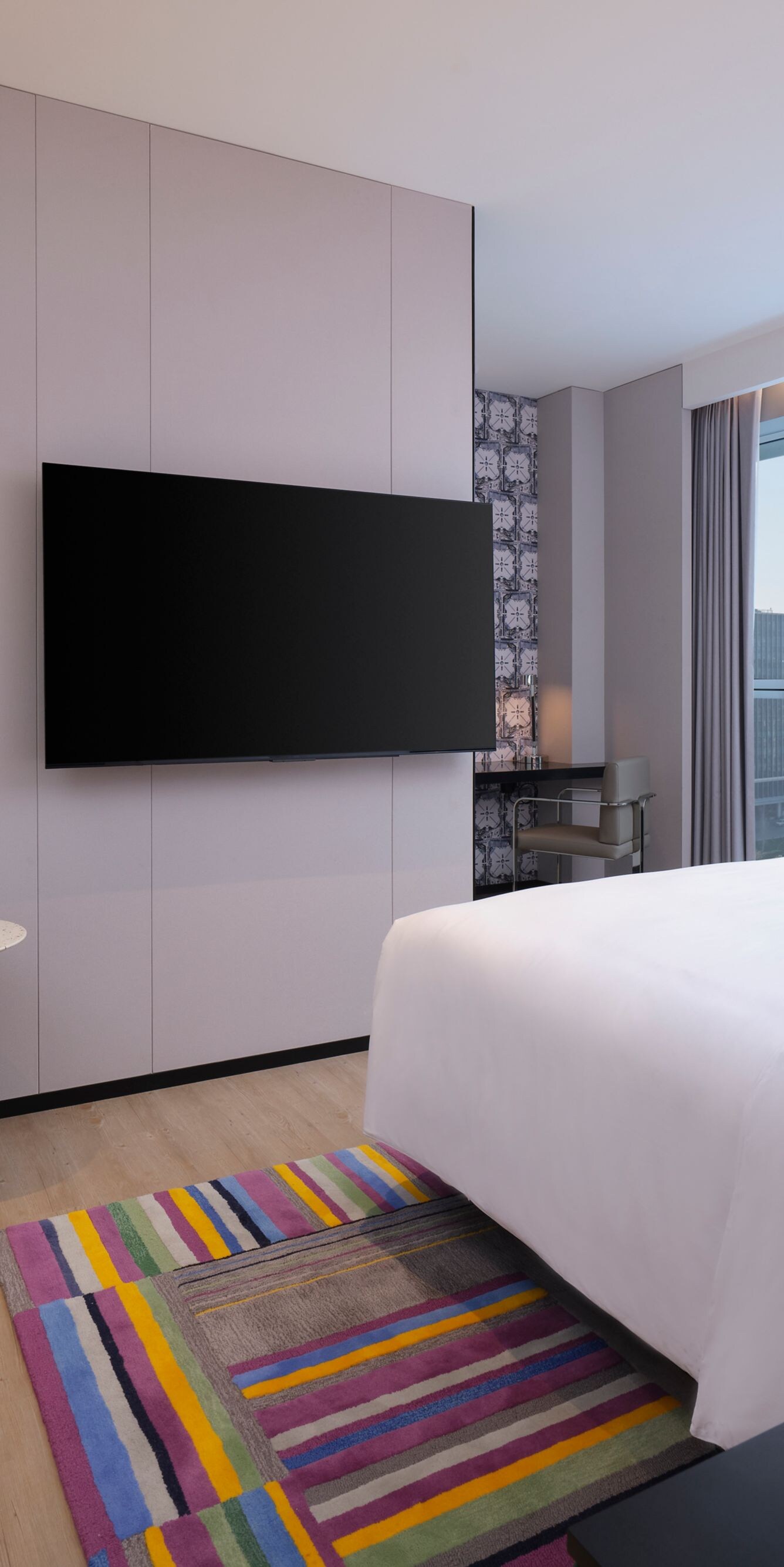 Guest room bed with chair, table, TV