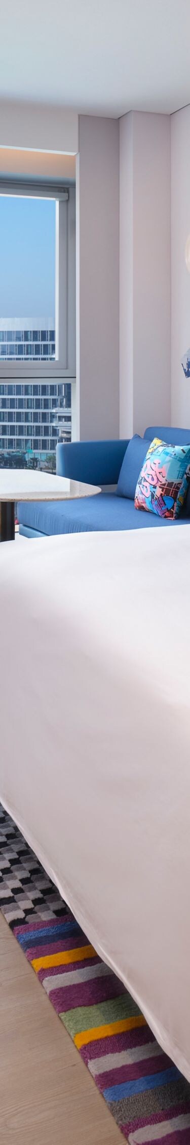 Guest room bed with sofa, chair, table, TV