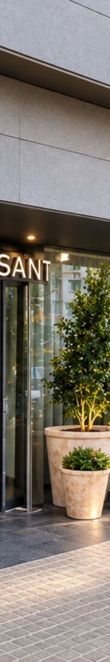 Fachada del hotel con plantas, bicicletas y puertas de cristal