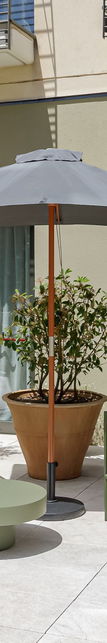 terraza con sillas bajas y mesa con sombrilla