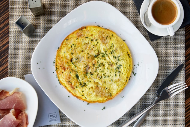 Tortilla Espanola on a plate with utensils.
