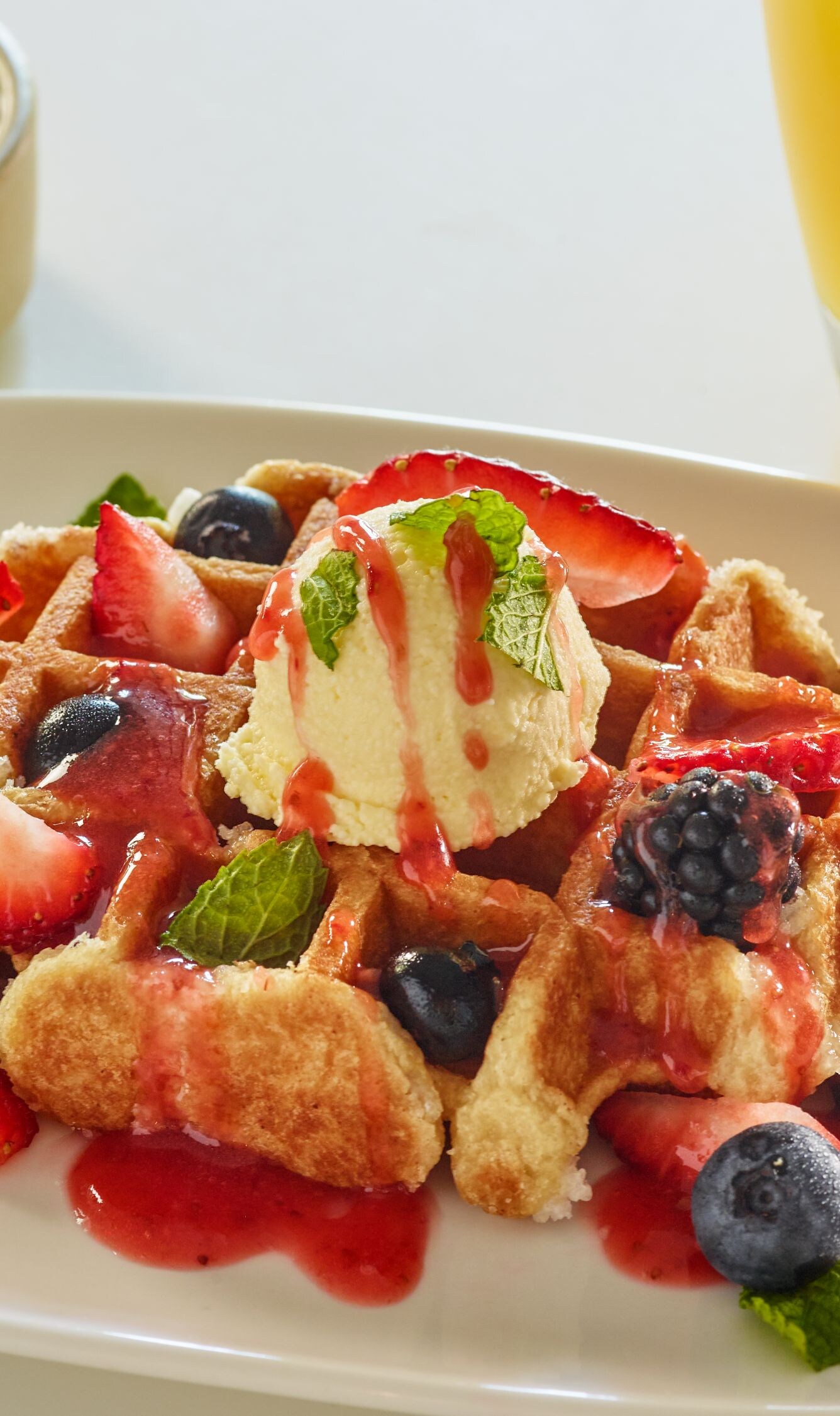 Belgian waffle with butter, syrup and berries