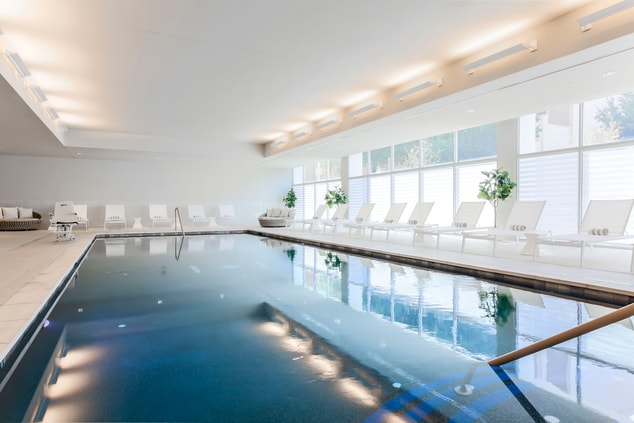 Indoor pool with chairs and plants
