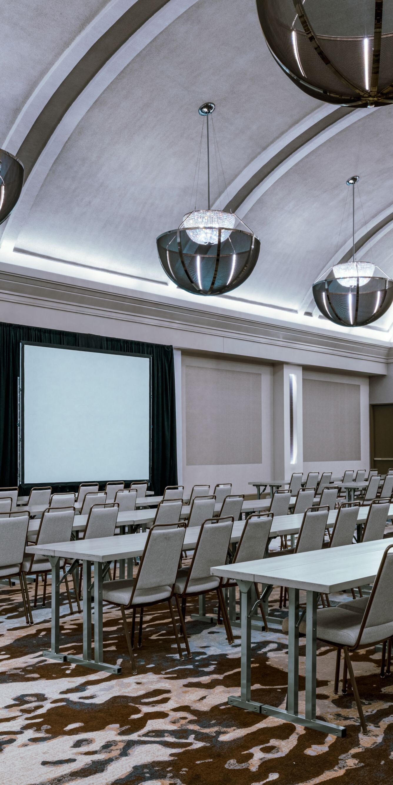 Salón con asientos en disposición estilo aula y pantalla de proyector