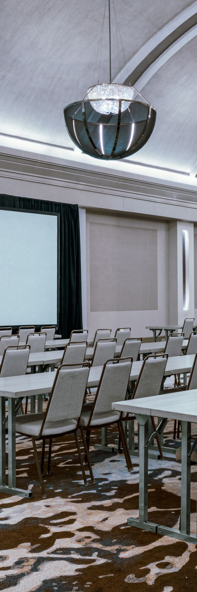Salón con asientos en disposición estilo aula y pantalla de proyector