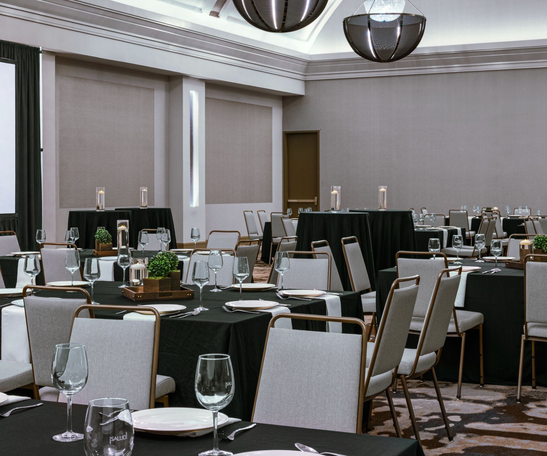 Ballroom with banquet tables and projector screen