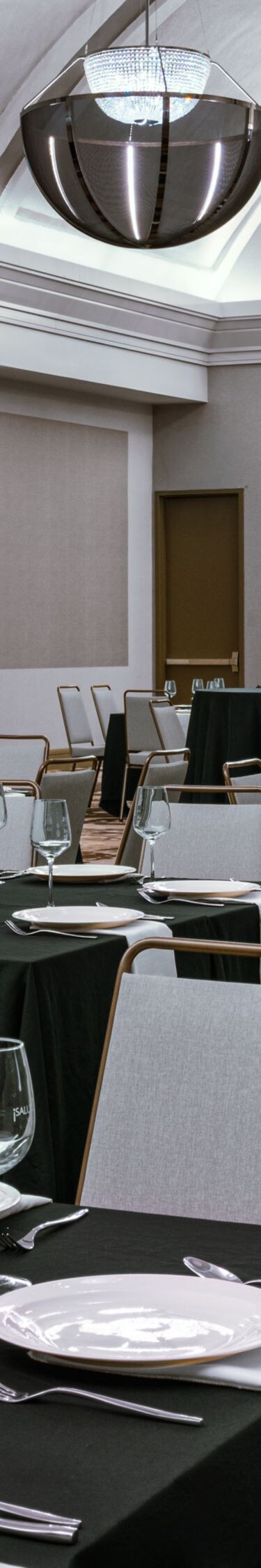 Salón con mesas de banquete y pantalla de proyector