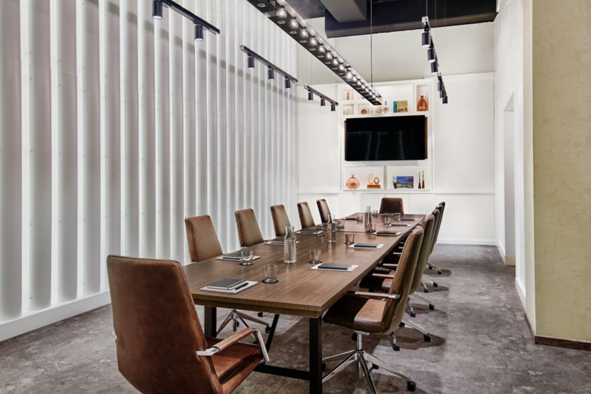 Large boardroom with long conference table and tv