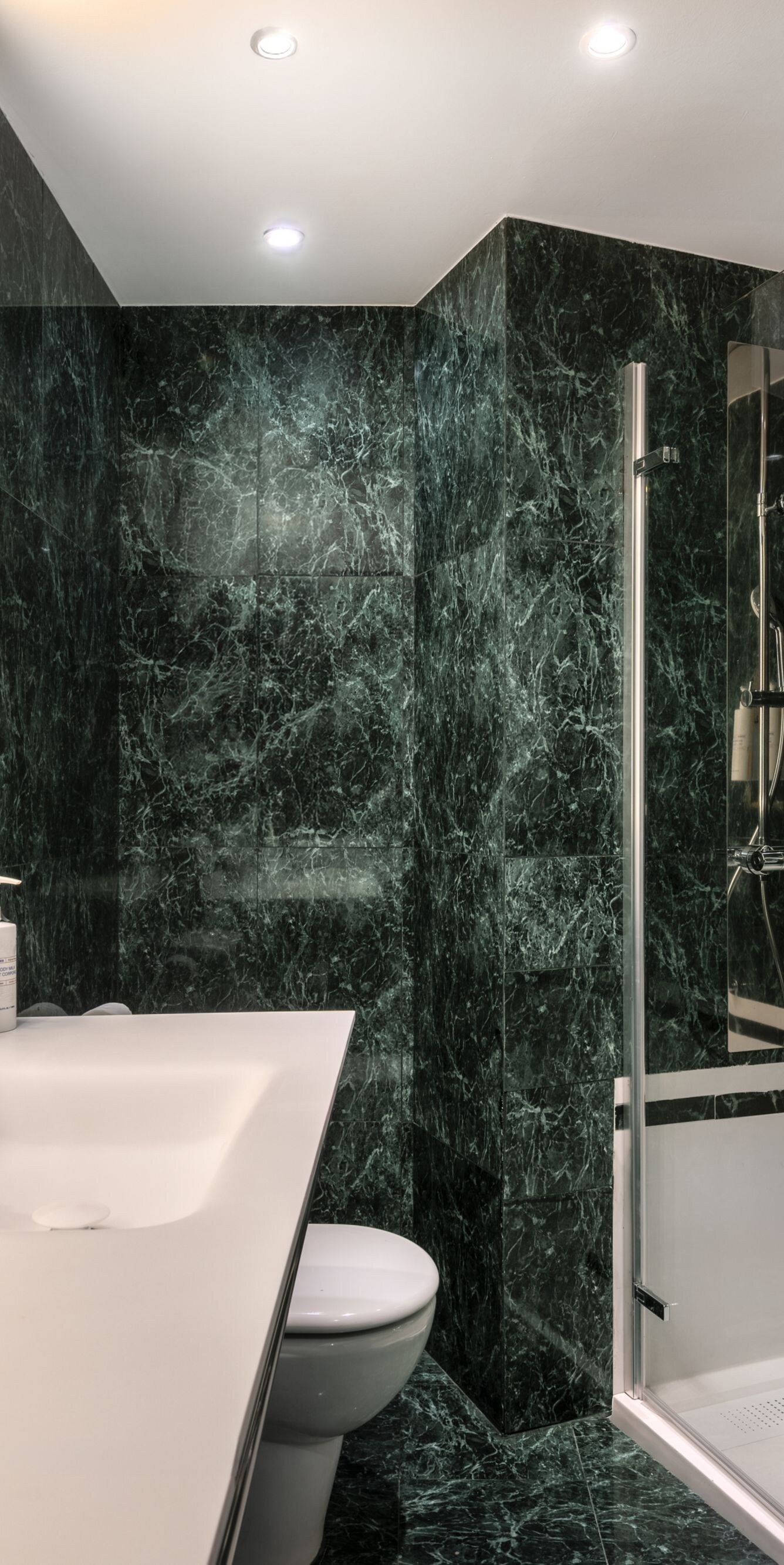Bathroom with green marble and glass shower