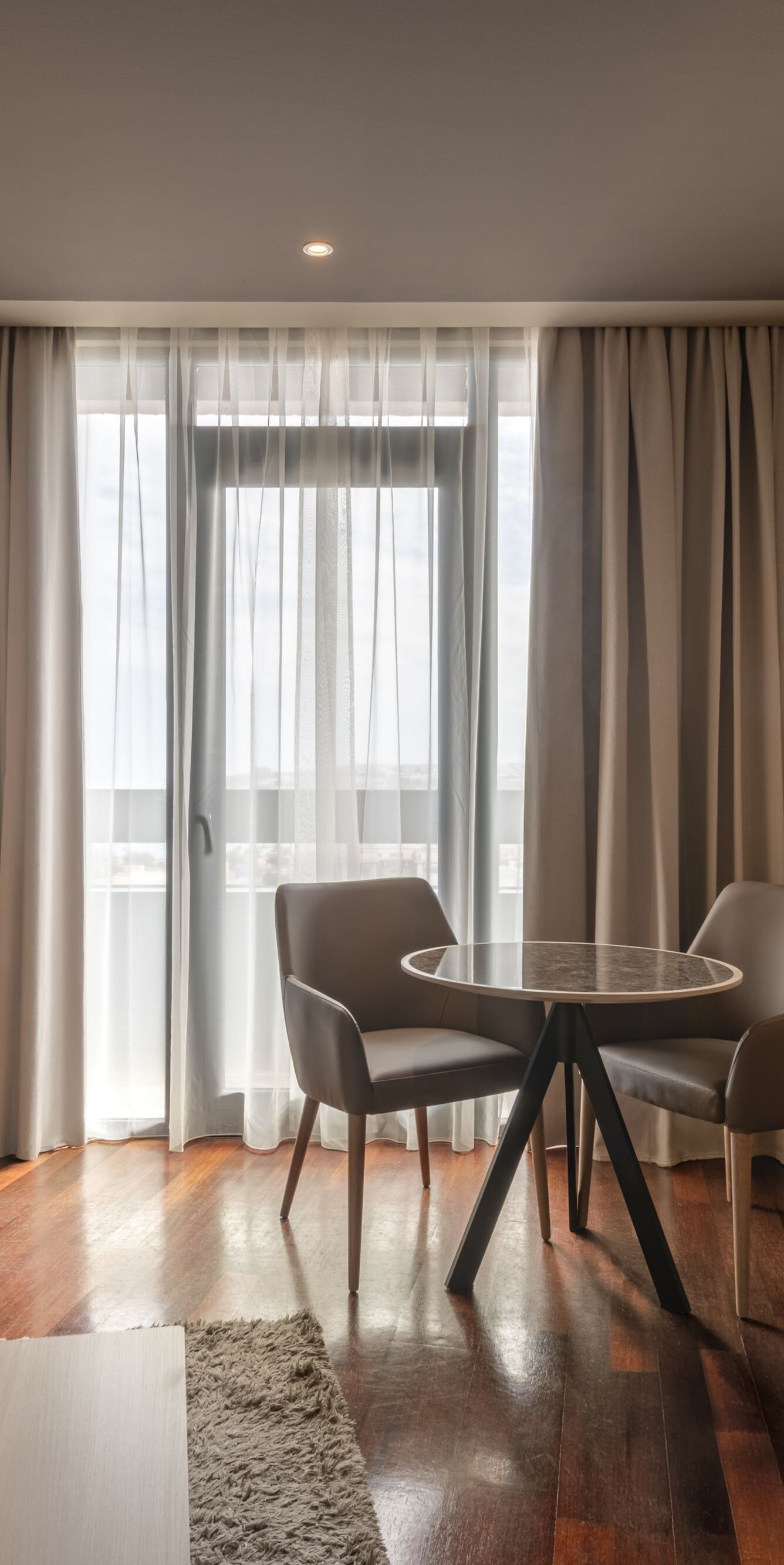 Suite living area with table and balcony