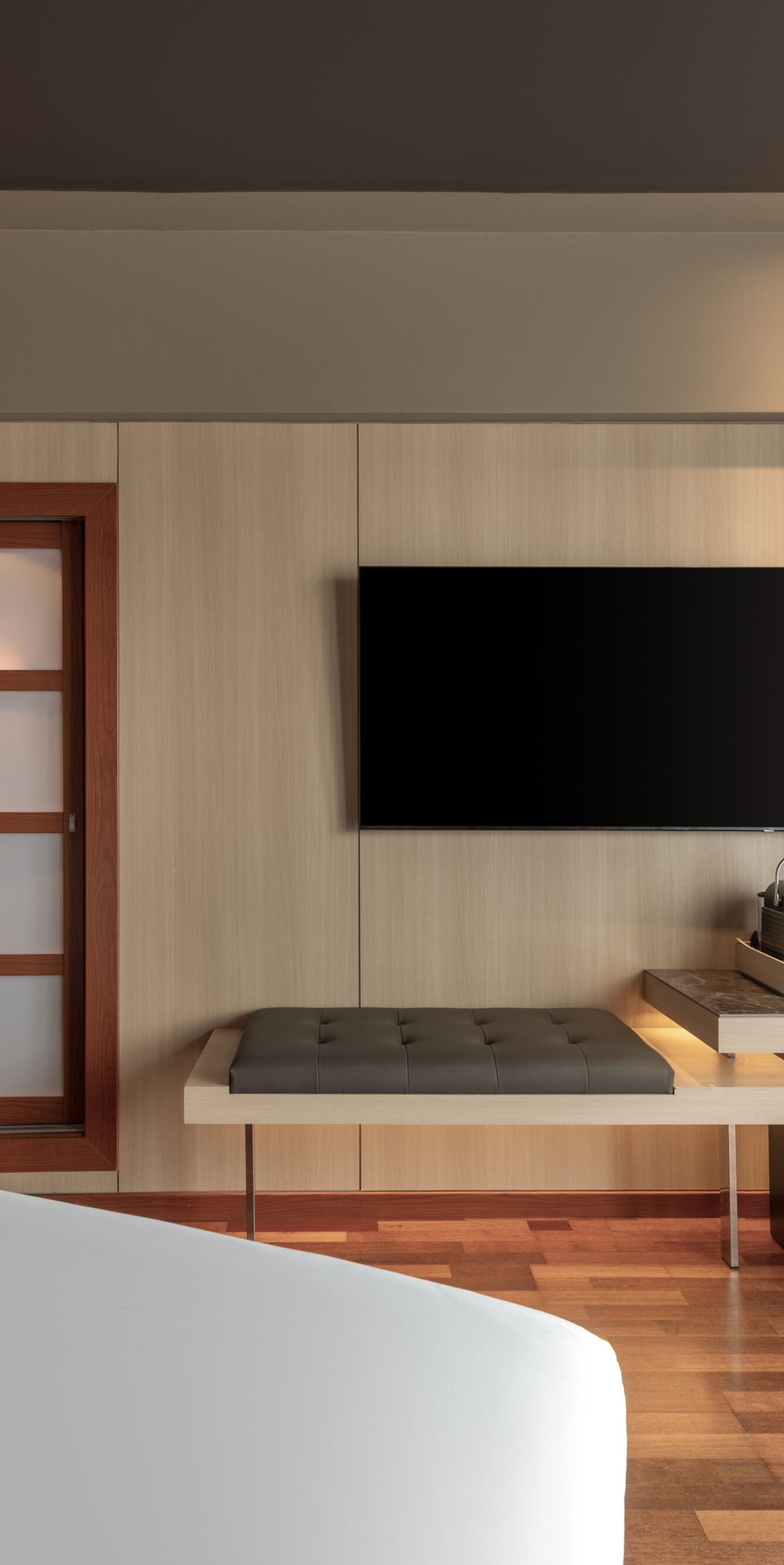 Guest room with flat-screen TV and bench