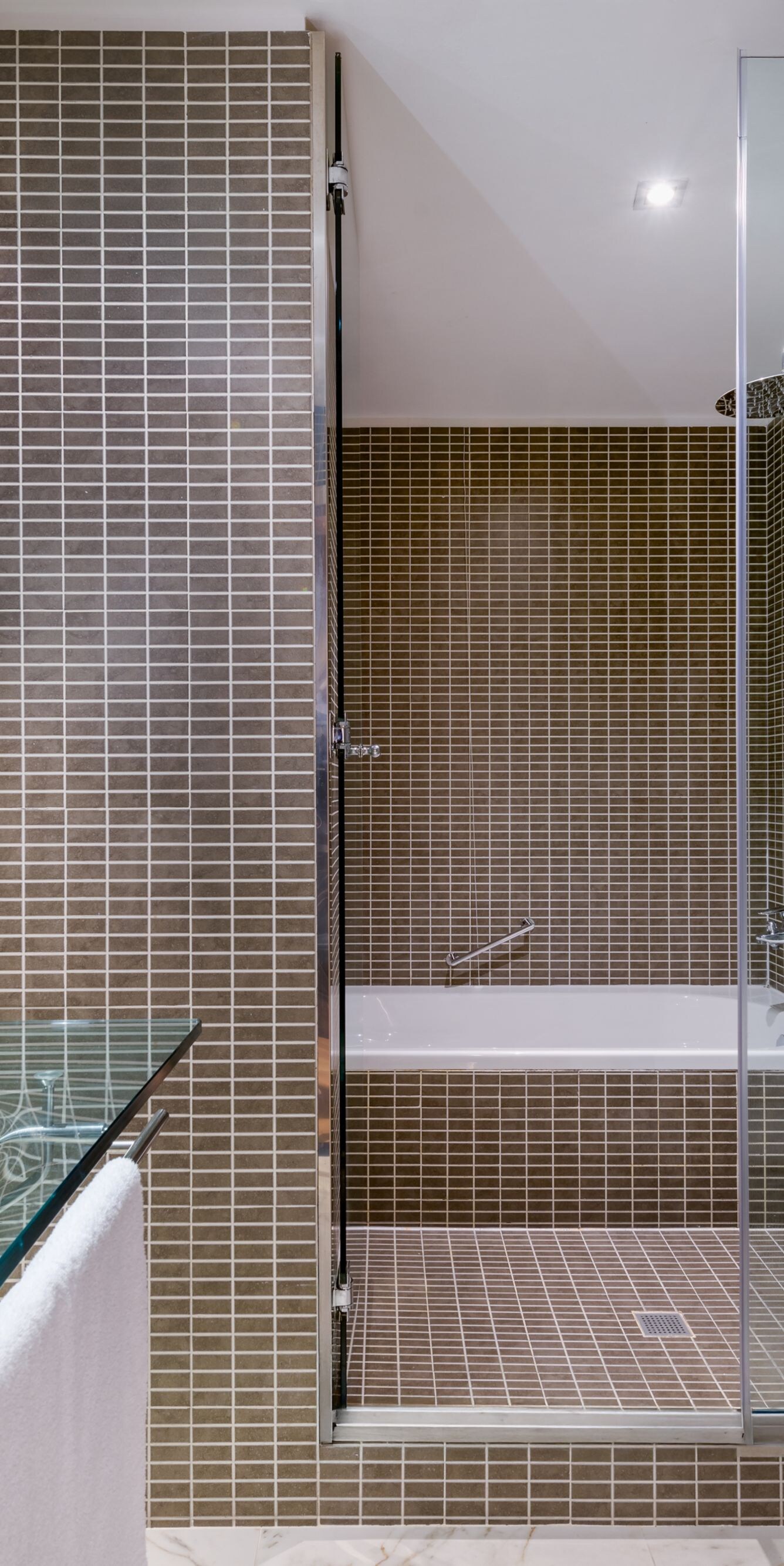Bathroom with glass sink and tub shower