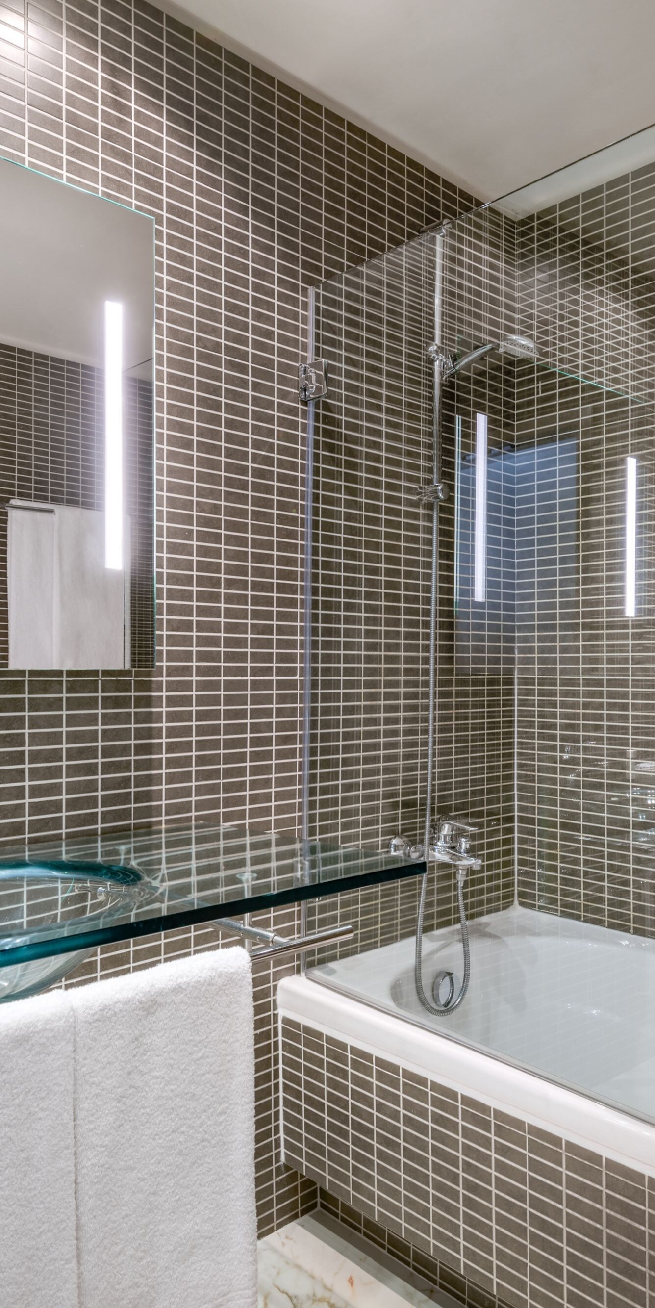 Modern bathroom with glass vanity and tub