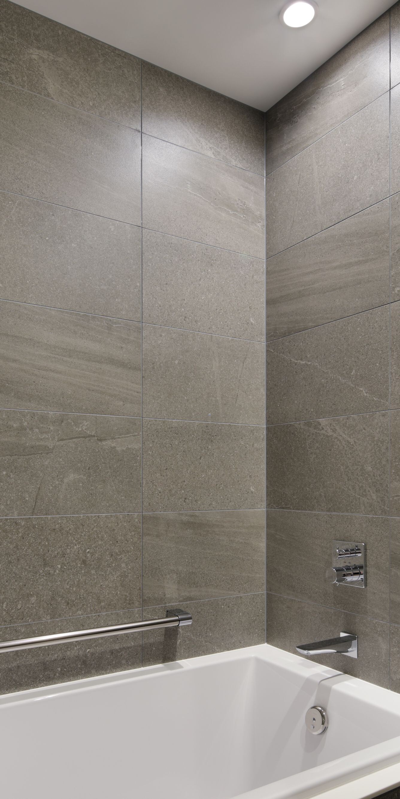 Bathroom with tub and stone tile walls