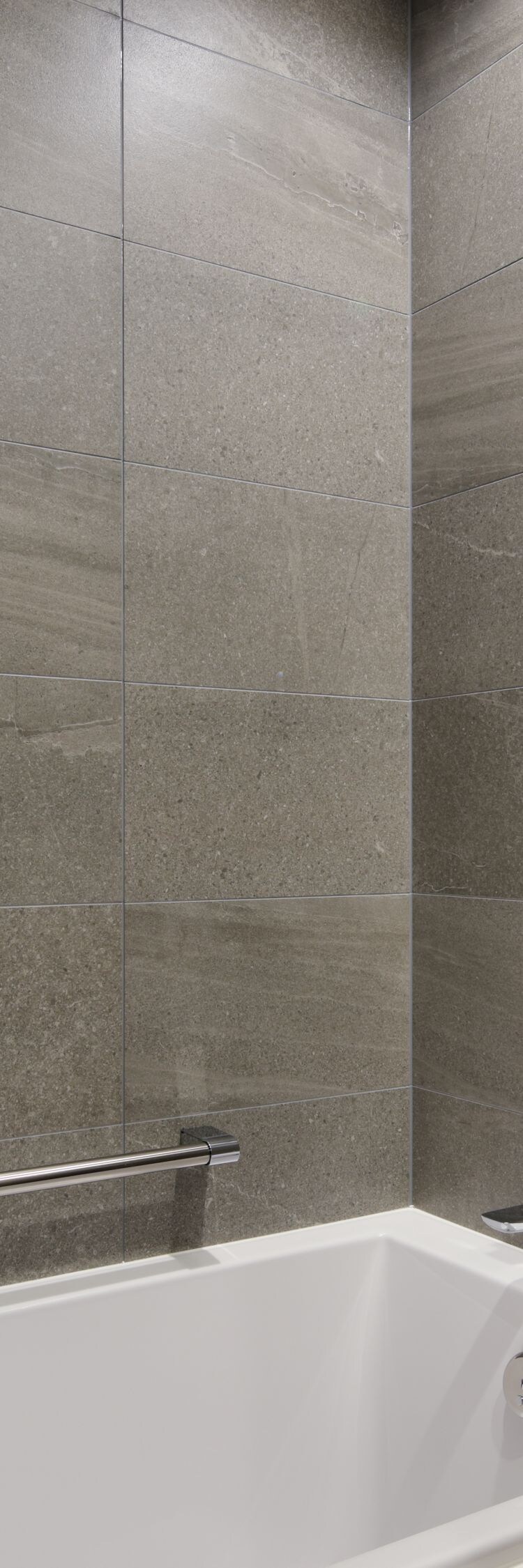 Bathroom with tub and stone tile walls