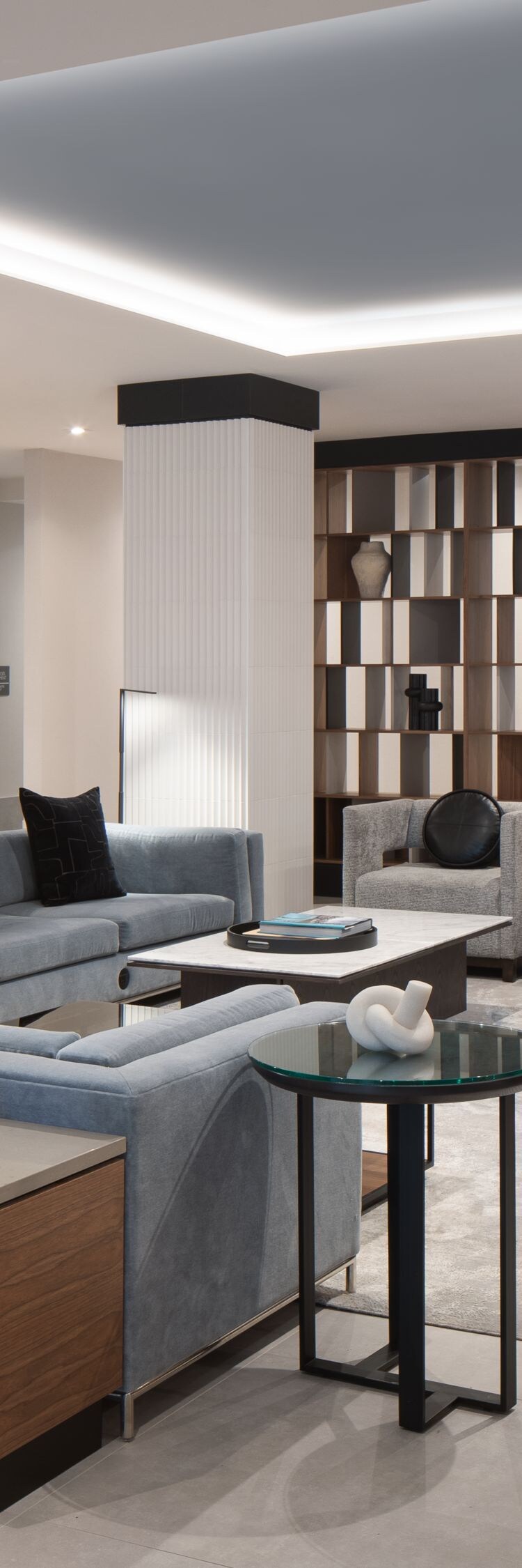 Modern hotel lobby seating area with bookshelves.