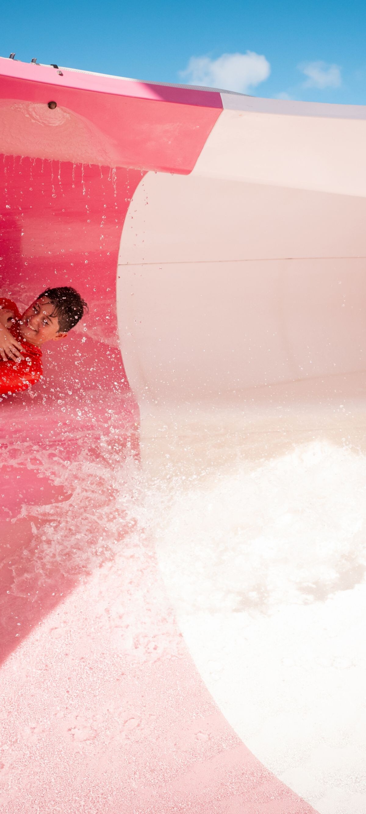 Person sliding down pink waterslide