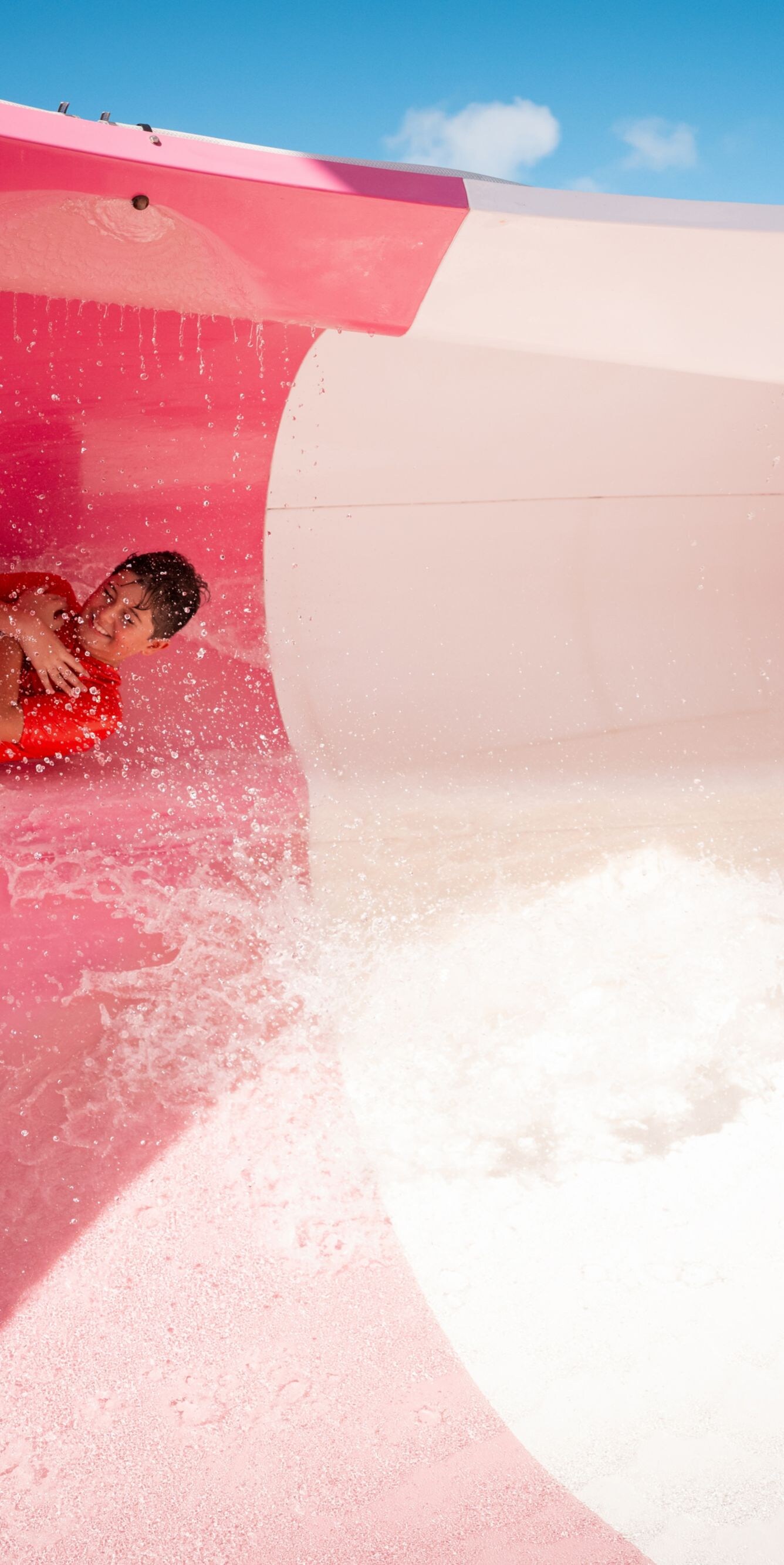 Person sliding down pink waterslide